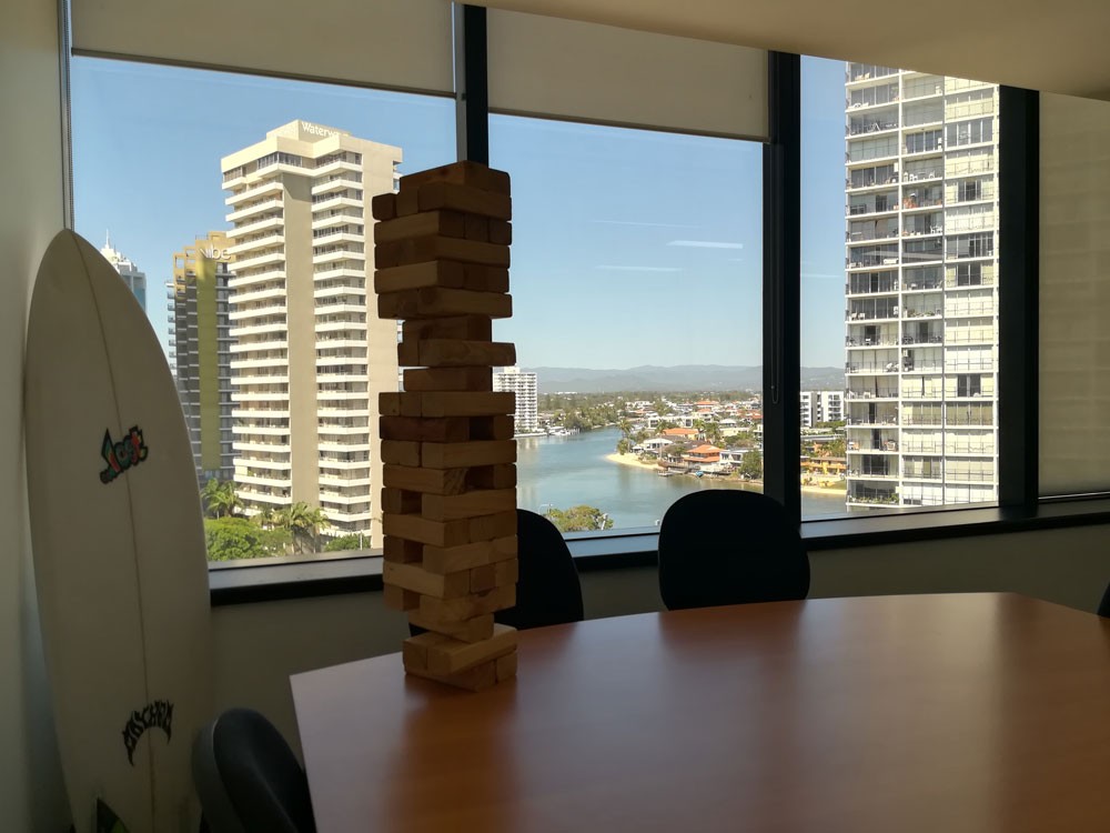 oficina de trabajo con vistas a los edificios altos de Gold Coast y una tabla de surf dentro de la oficina